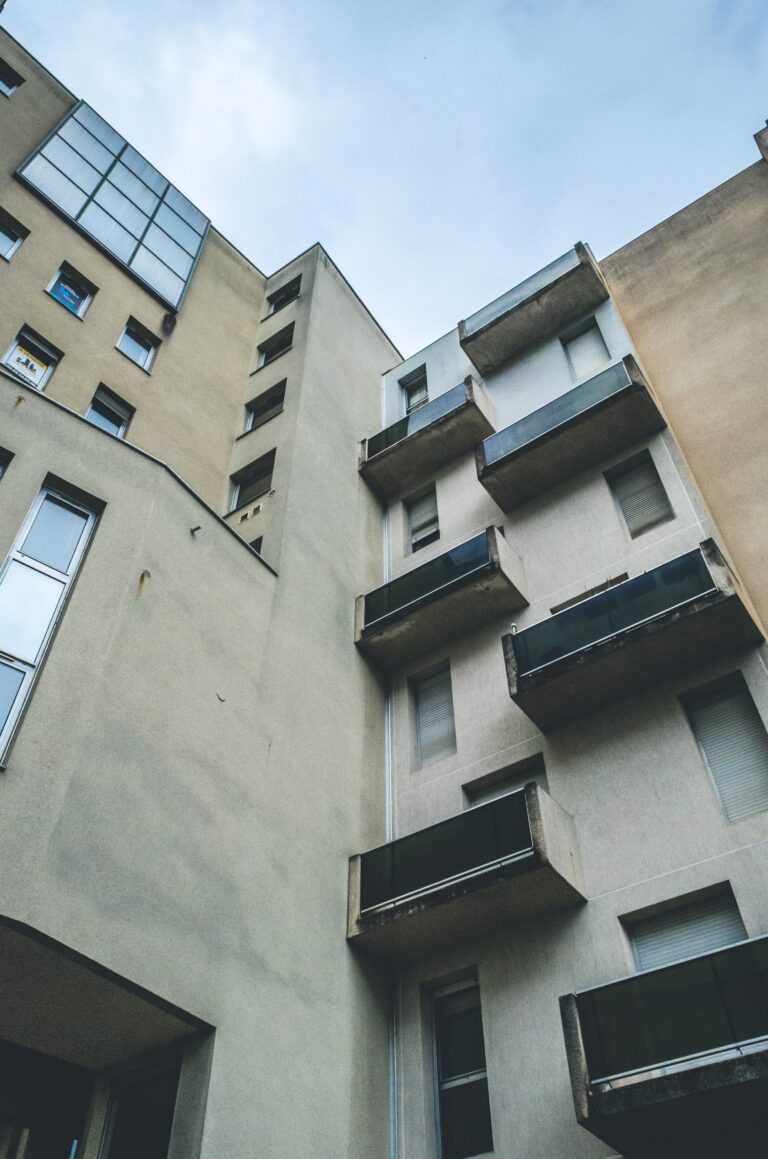 Vertical low angle shot of a brown abstract architectural building with balconies and windows